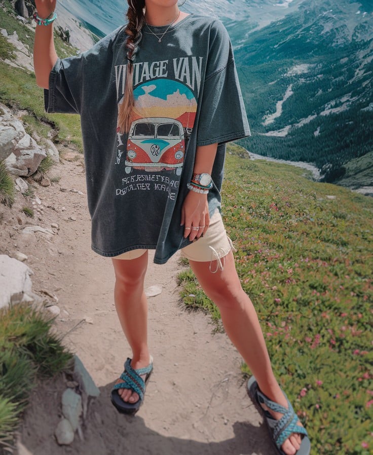 Woman-on-mountain-trail-wearing-vintage-van-t-shirt-summer-hiking-outfit-with-sandals