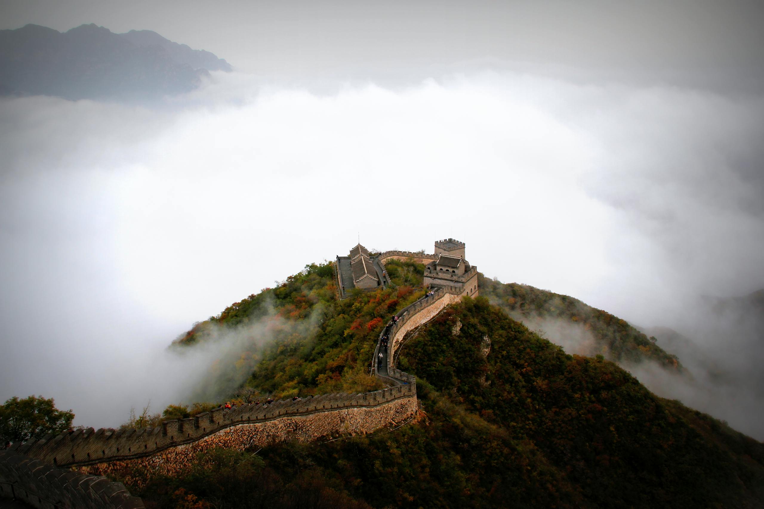 Majestic aerial shot of the Great Wall of China surrounded by mist and mountains.